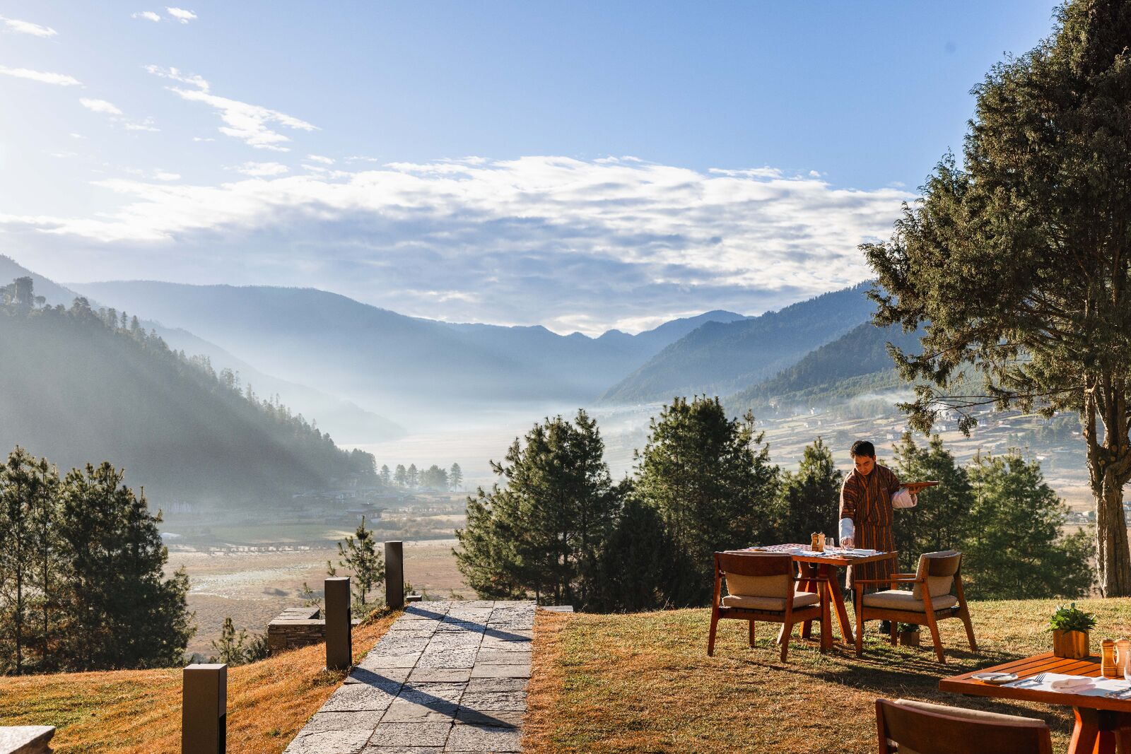 Outdoor dining overlooking misty Bhutanese valley